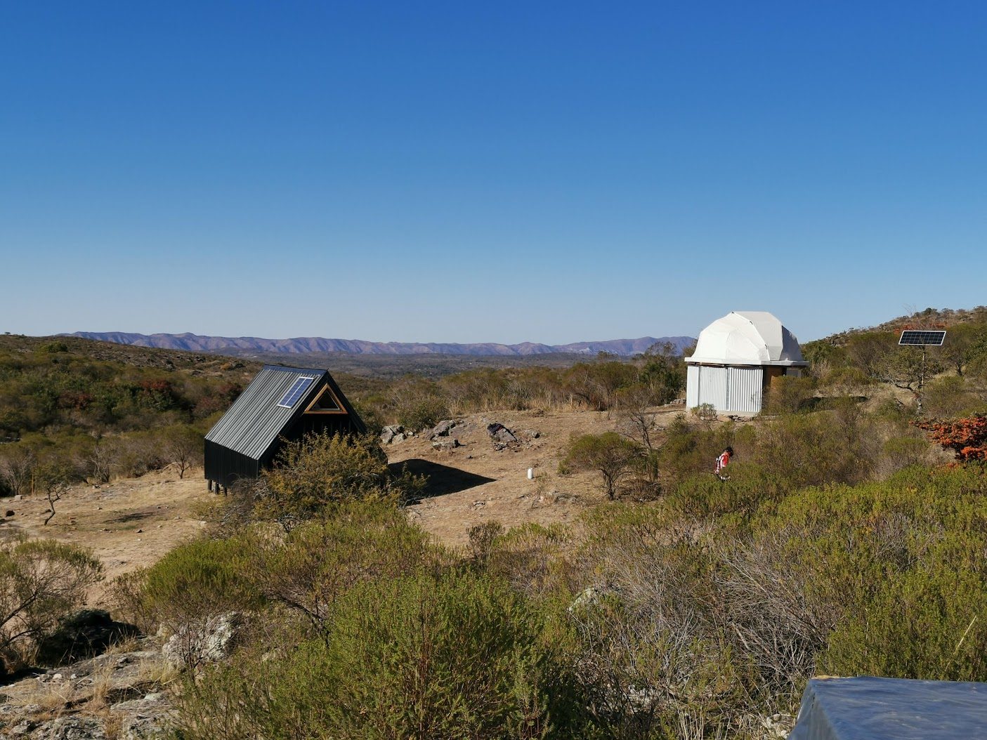 Vista del predio con el domo del observatorio y la casa de campo sobre las sierras