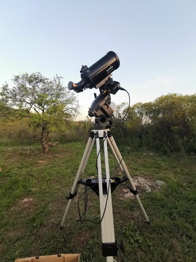 Telescopio montado a campo abierto al atardecer